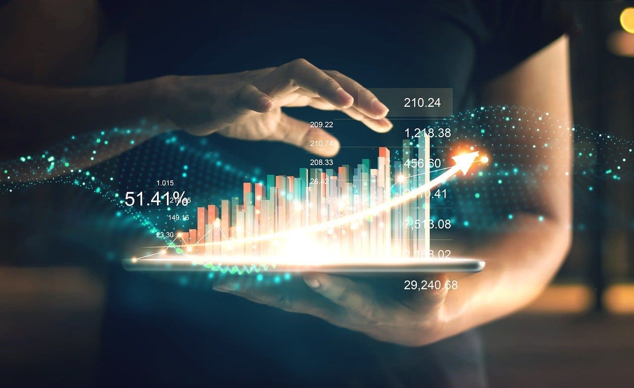 Imagen que muestra el torso de una persona de fondo sosteniendo una tablet sobre una de sus manos y extrayendo los gráficos que contiene con la otra mano. Concepto del Big Data